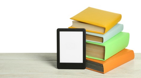 Stack of hardcover books and modern e-book on wooden table against white background. Space for text