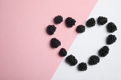 Flat lay composition with ripe blackberries on color background