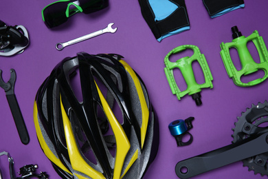 Set of different bicycle tools, accessories and parts on purple background, flat lay