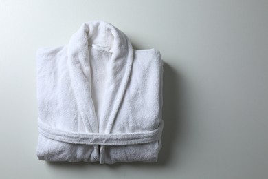 Photo of Clean folded bathrobe on white background, top view