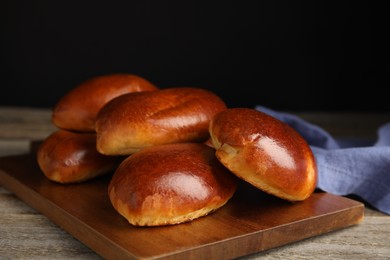 Photo of Baked pirozhki on wooden table. Delicious pastry