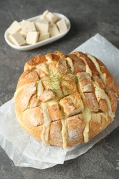 Photo of Freshly baked bread with tofu cheese on grey table