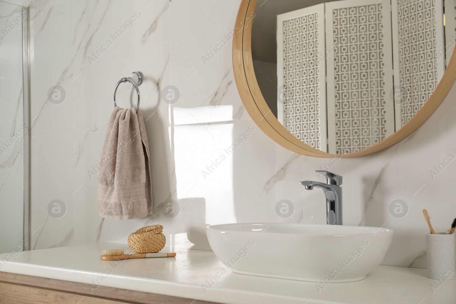 Photo of Bathroom interior with mirror, countertop and soft towel on wall