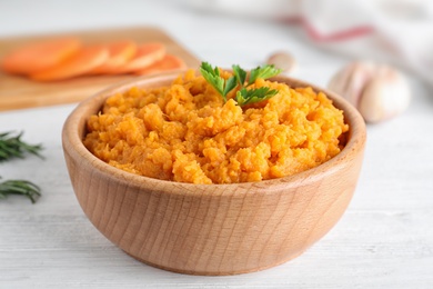 Bowl with mashed sweet potatoes on wooden table