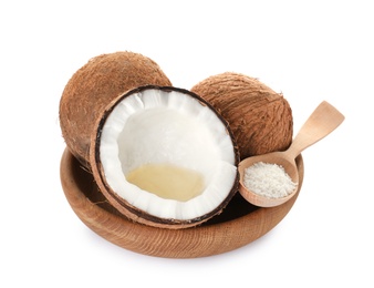 Photo of Wooden bowl of coconuts, natural organic oil and spoon isolated on white