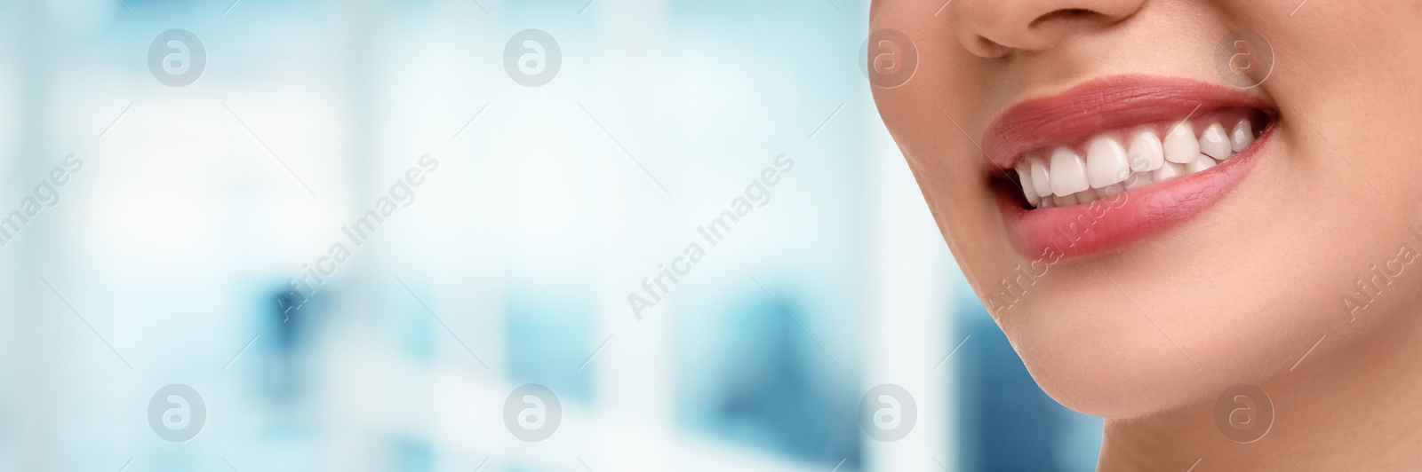 Image of Woman with clean teeth smiling on blurred background, closeup. Banner design with space for text