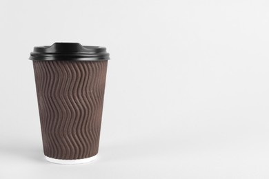 Brown paper cup with plastic lid on light background, space for text. Coffee to go