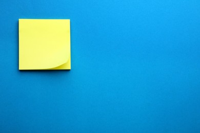 Photo of Paper note on blue background, top view. Space for text