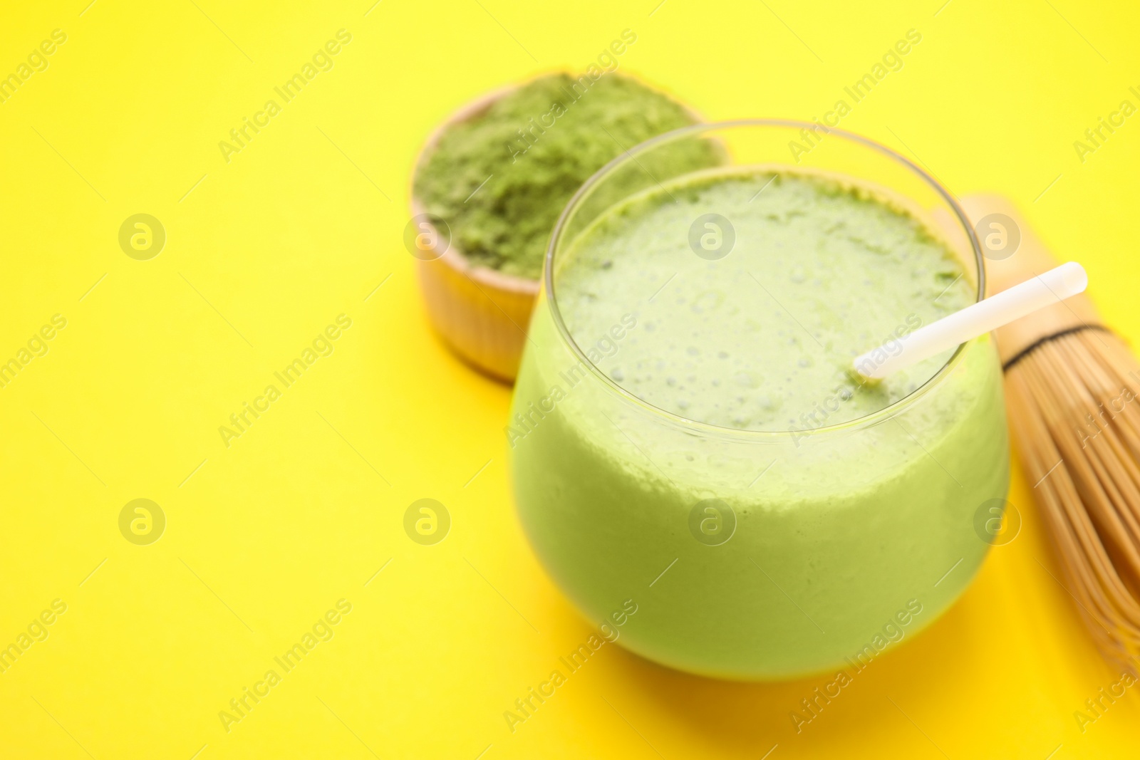 Photo of Glass of tasty matcha smoothie on yellow background, closeup. Space for text