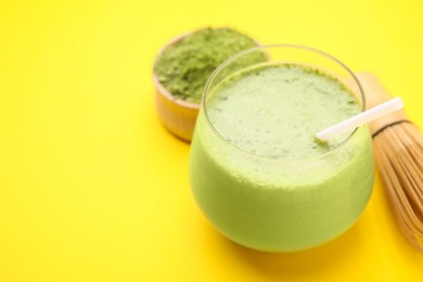 Photo of Glass of tasty matcha smoothie on yellow background, closeup. Space for text