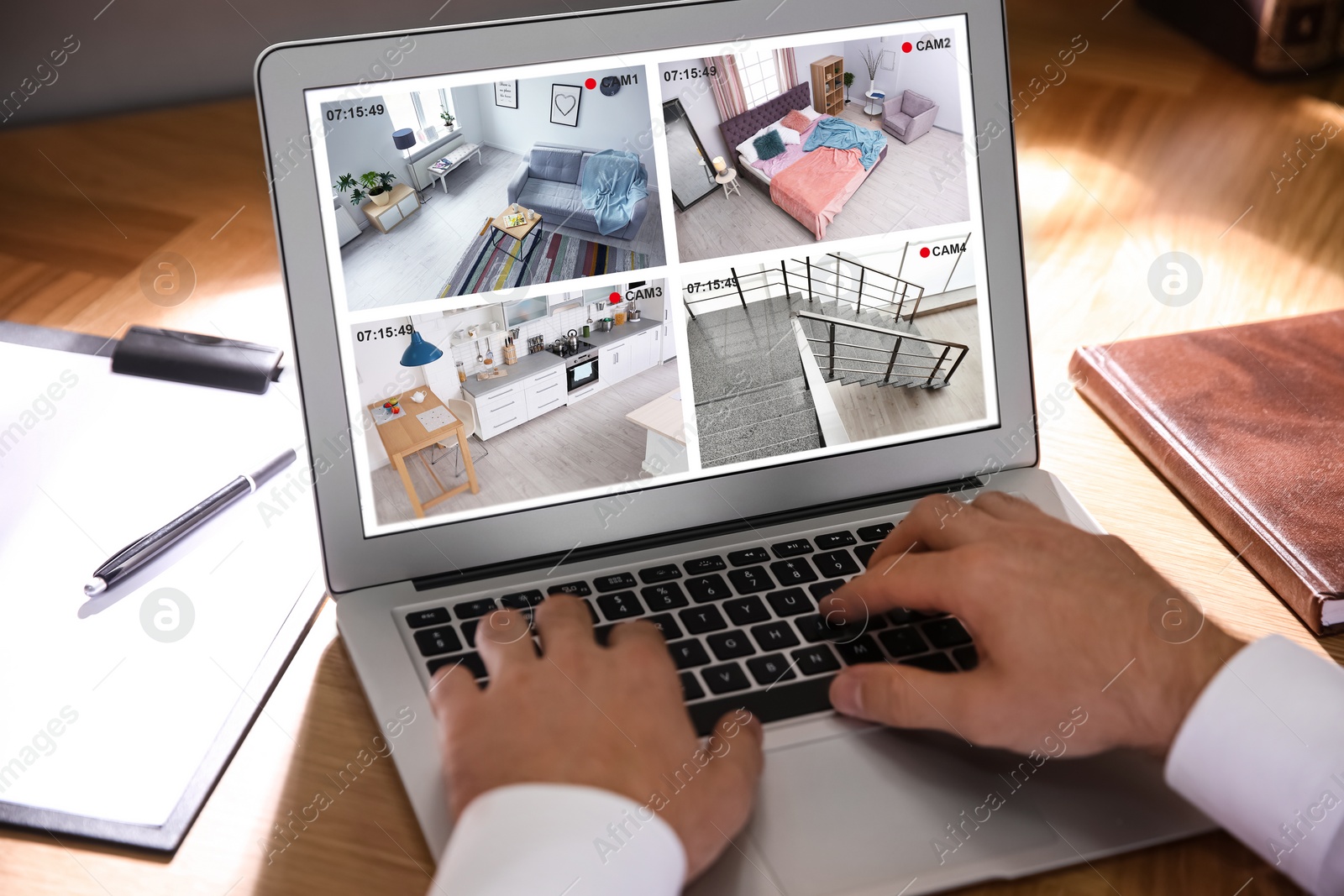 Image of Man monitoring modern CCTV cameras at wooden table, closeup. Smart home security system