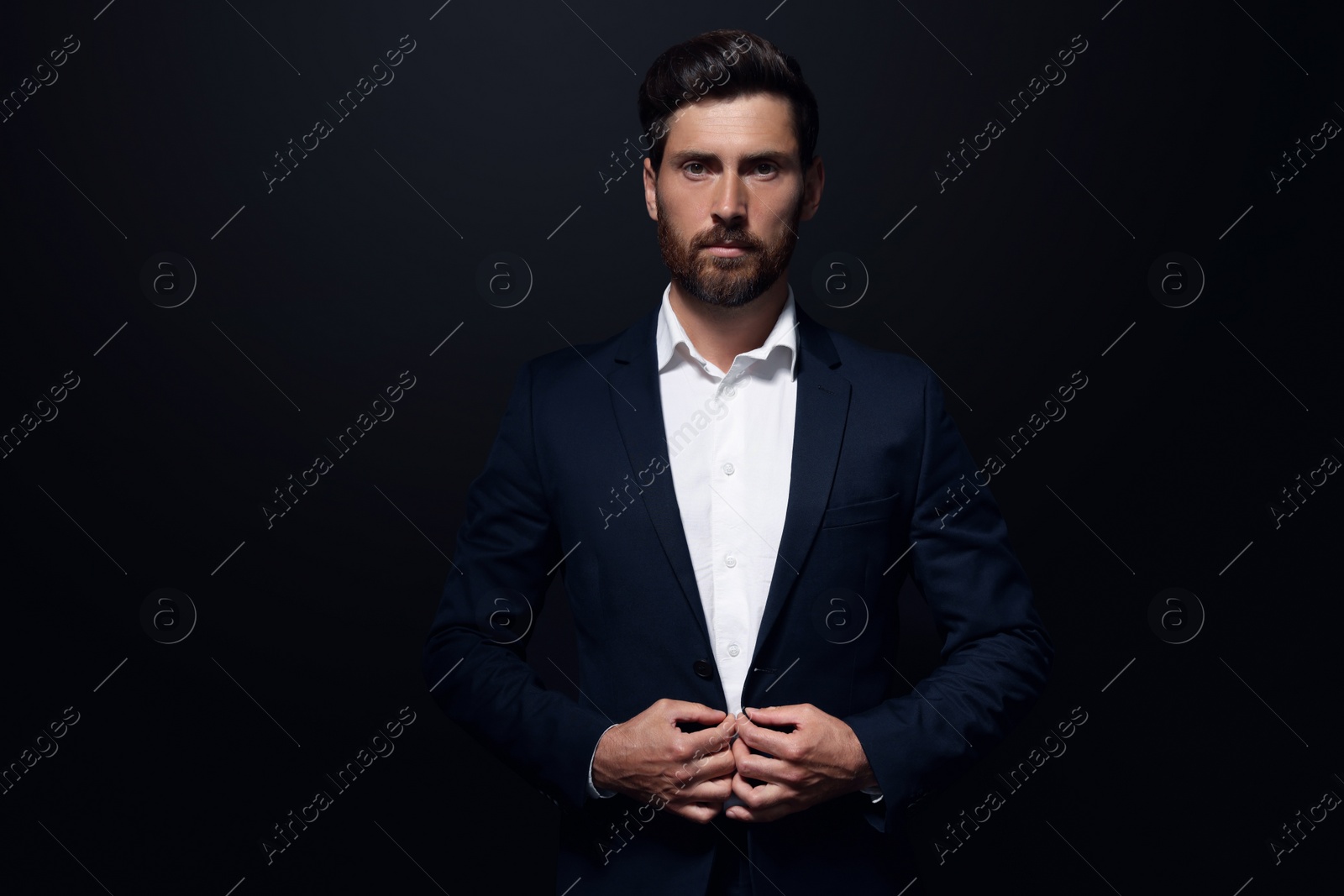 Photo of Portrait of handsome bearded man on black background