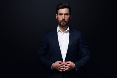 Photo of Portrait of handsome bearded man on black background