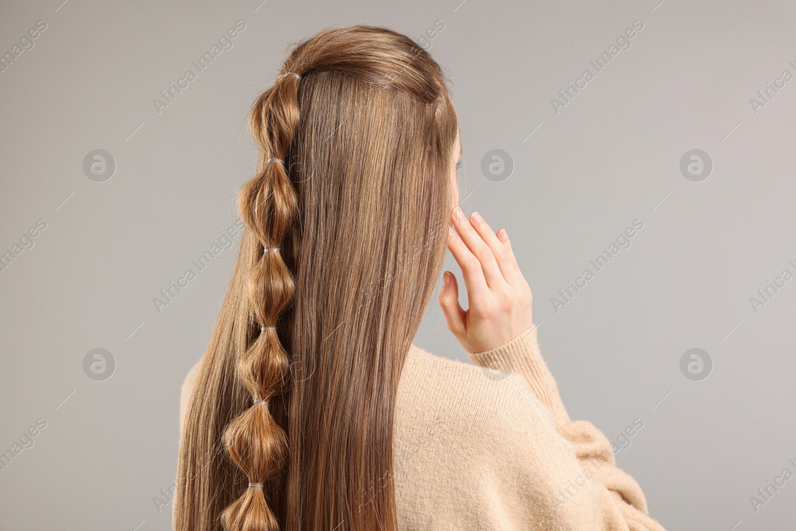 Photo of Woman with braided hair on grey background, back view