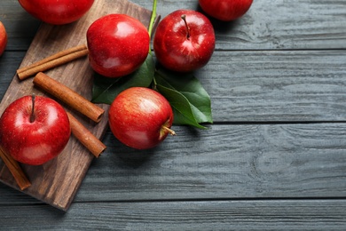 Photo of Fresh apples and cinnamon sticks on wooden table