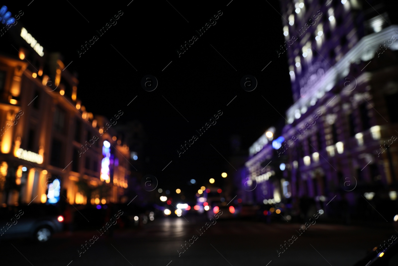 Photo of Blurred view of city street with lights at night. Bokeh effect