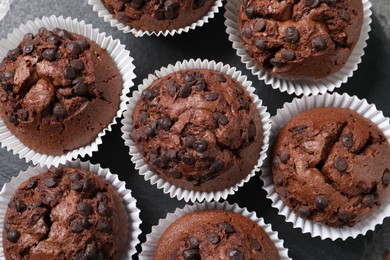 Photo of Tasty chocolate muffins on slate plate, top view