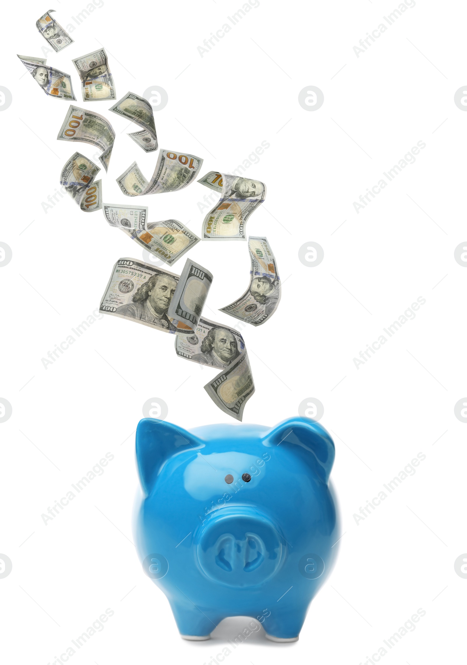 Image of Dollars falling into blue piggy bank on white background 