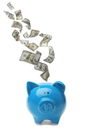 Image of Dollars falling into blue piggy bank on white background 