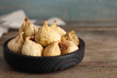 Photo of Tasty dried figs in plate on wooden table