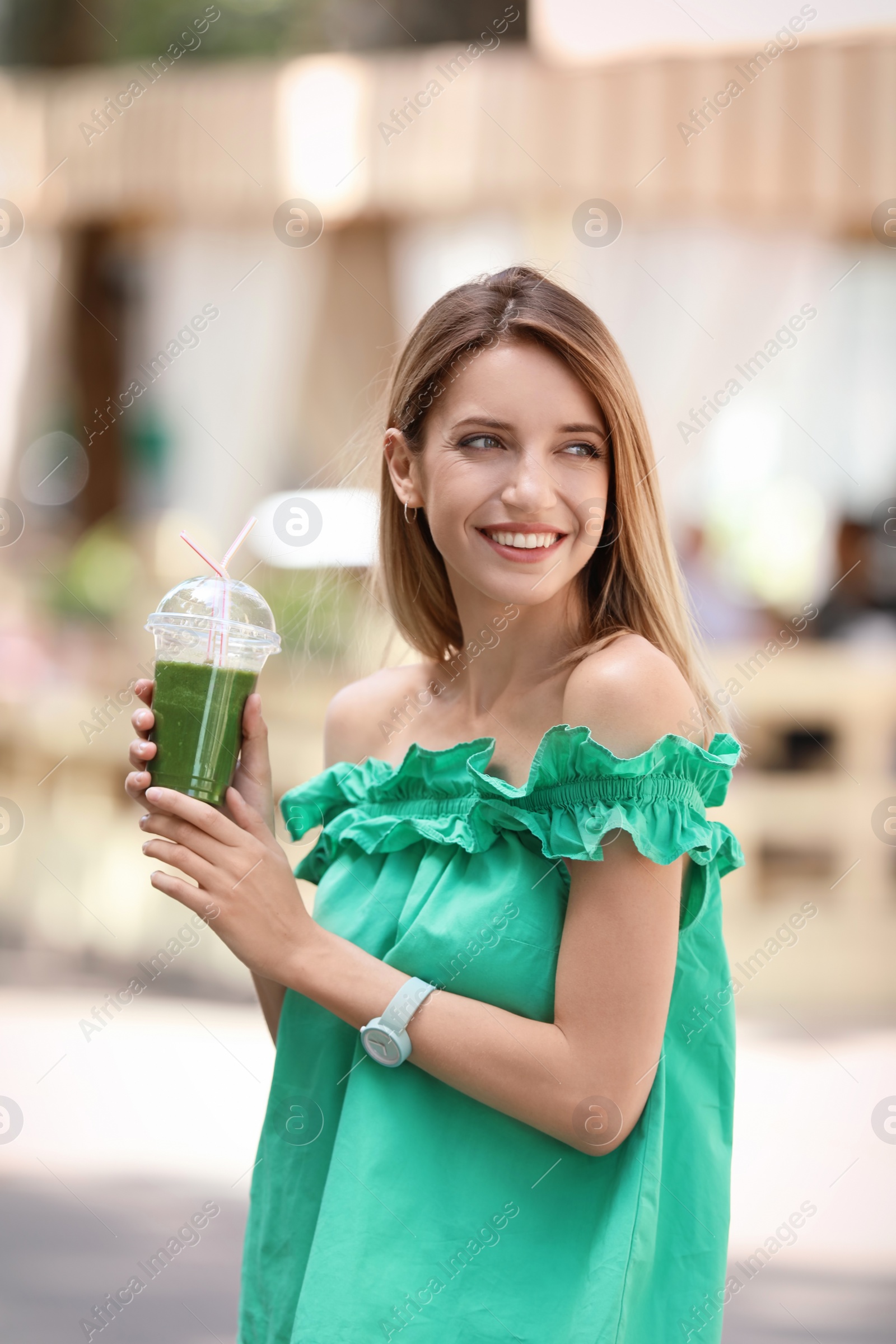 Photo of Young woman with plastic cup of healthy smoothie outdoors