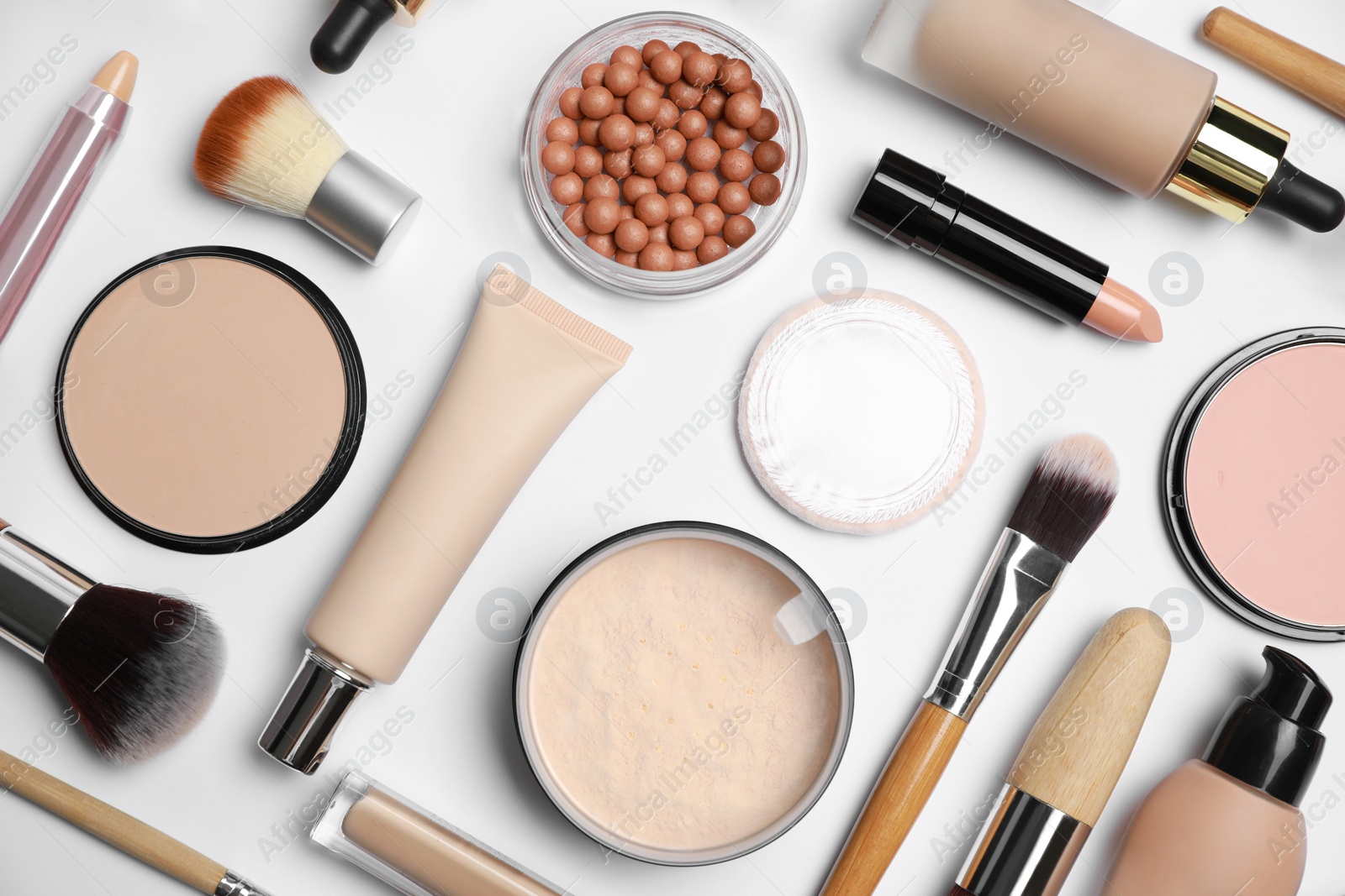 Photo of Face powders and other makeup products on white background, flat lay