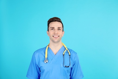 Portrait of medical assistant with stethoscope on color background