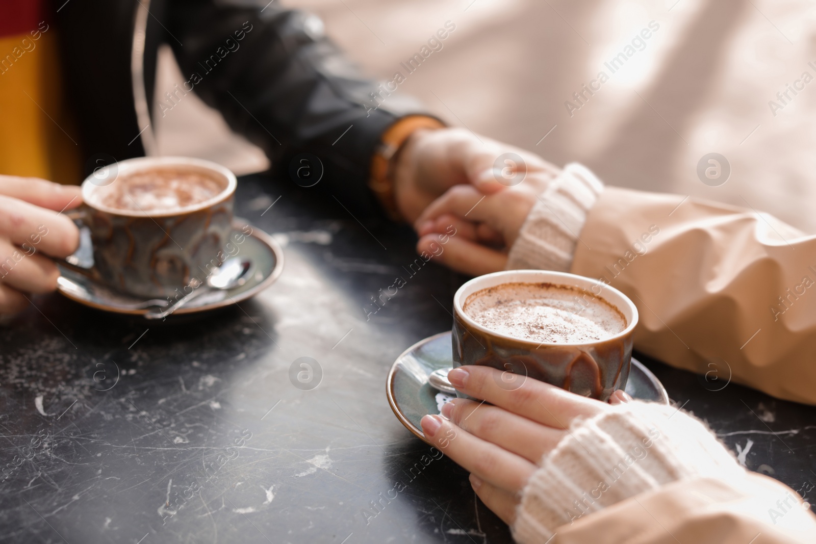 Photo of Couple enjoying tasty aromatic coffee at table, closeup view