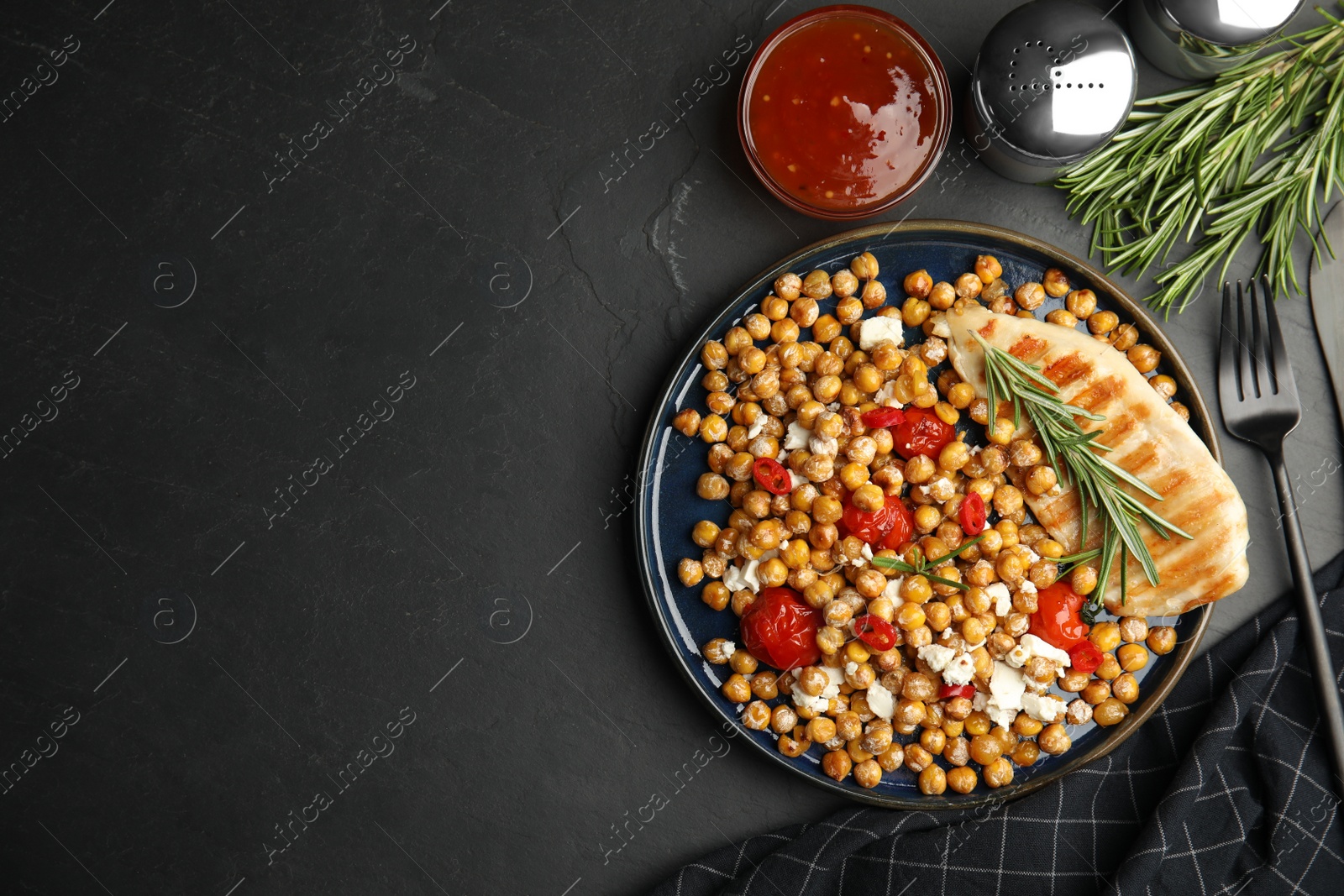 Photo of Delicious fresh chickpea salad served on black table, flat lay. Space for text
