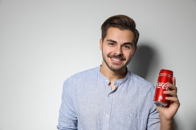 MYKOLAIV, UKRAINE - NOVEMBER 28, 2018: Young man with Coca-Cola can on white background