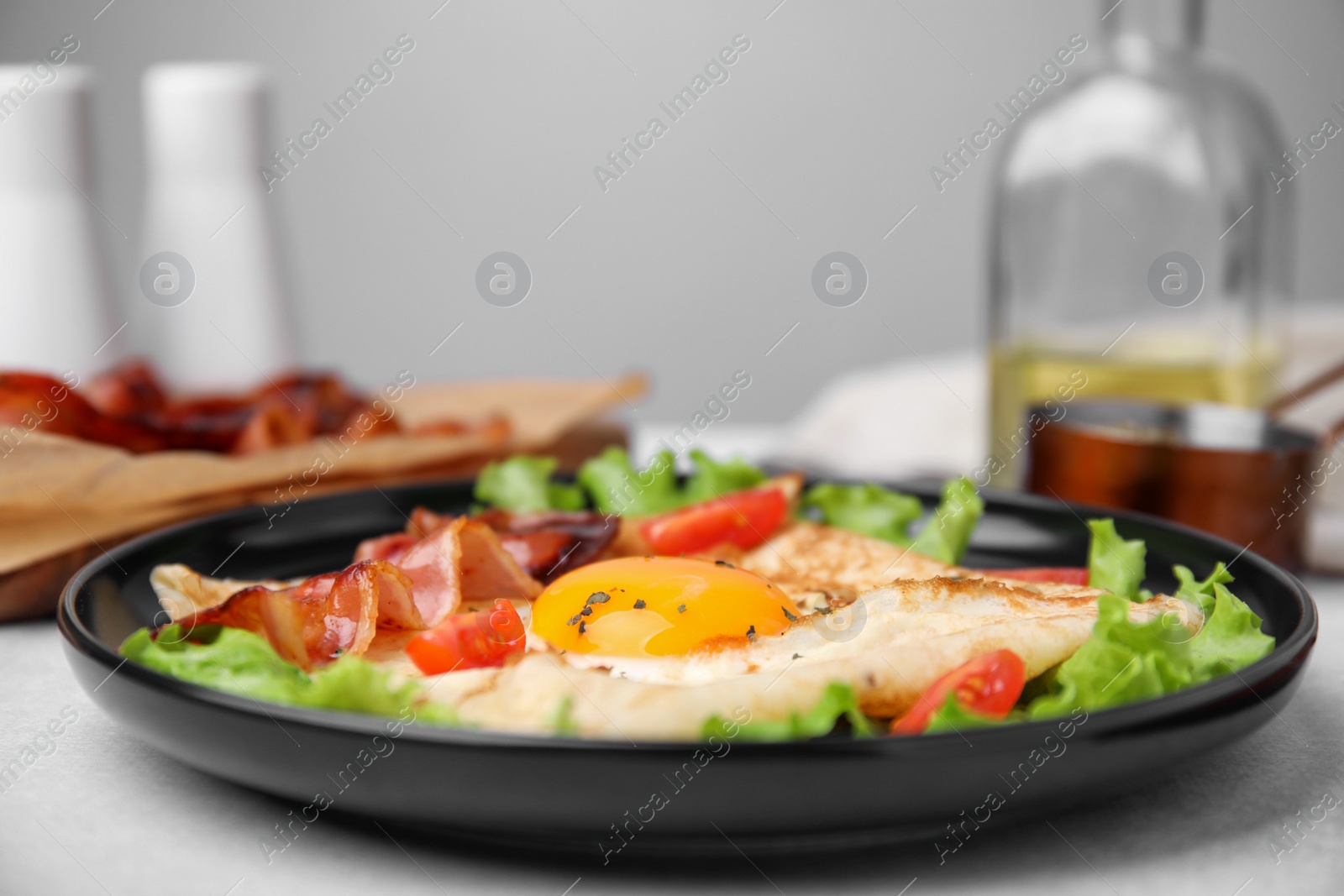 Photo of Delicious crepe with egg served on light gray table, closeup. Breton galette