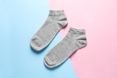 Photo of Pair of grey socks on colorful background, flat lay