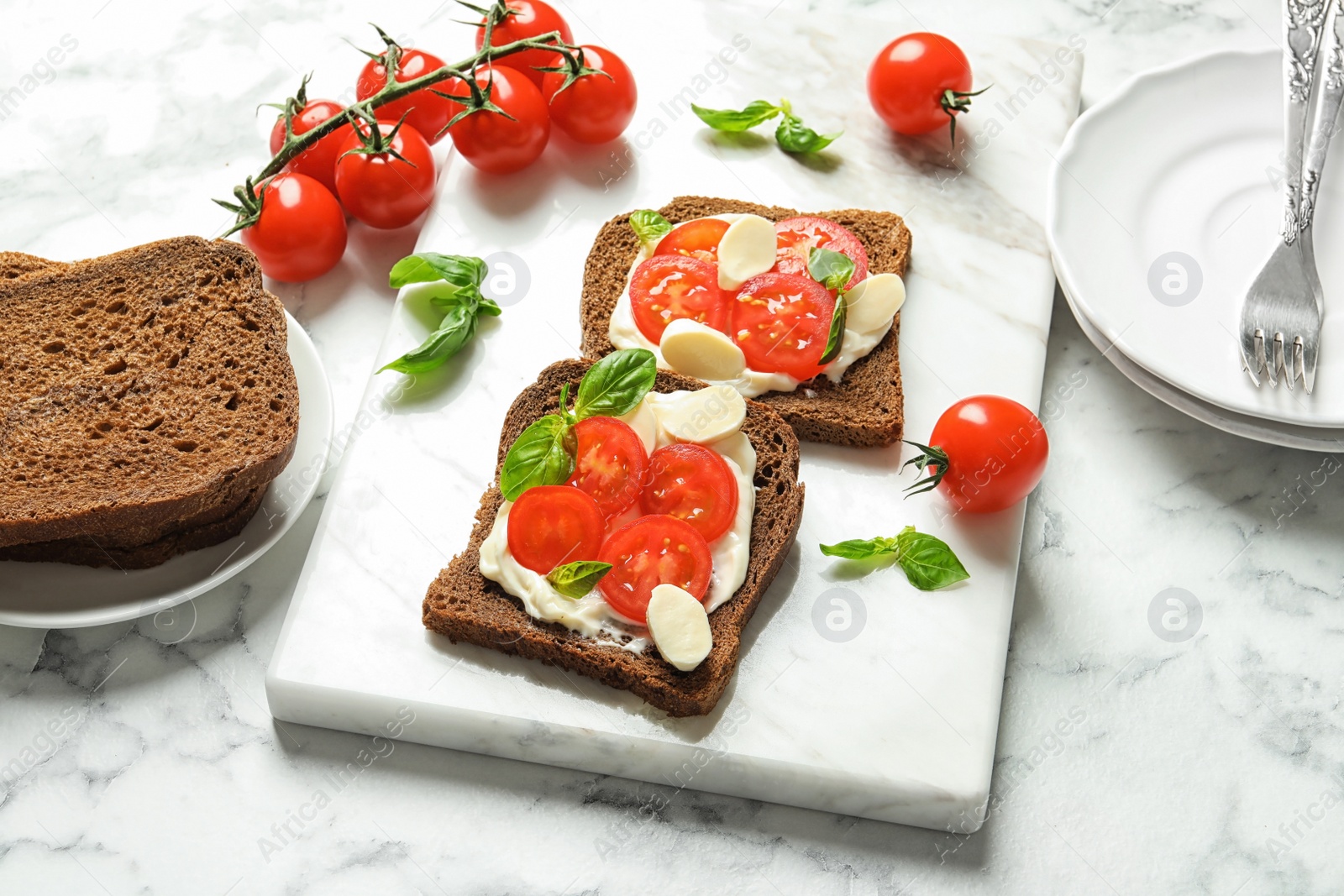 Photo of Toast bread with cherry tomatoes and mozzarella cheese on table