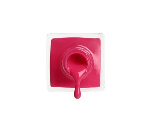 Photo of Pouring color nail polish from bottle on white background