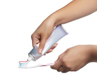 Photo of Woman applying toothpaste on brush against white background, closeup