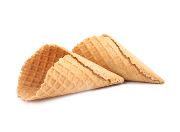 Photo of Empty crispy waffle cones for ice cream on white background