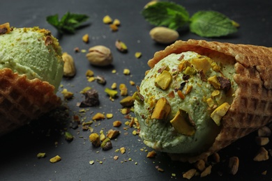 Photo of Delicious pistachio ice cream on dark table, closeup