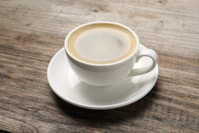 Photo of Aromatic coffee in cup on wooden table