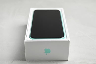 Photo of MYKOLAIV, UKRAINE - JULY 10, 2020: New modern Iphone 11 in original box on light grey table