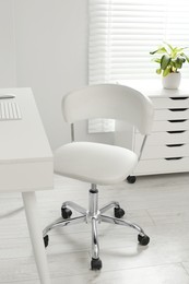 Photo of Stylish office chair at workplace in room. Interior design