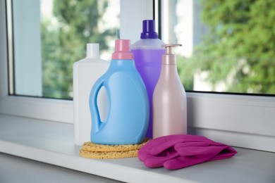 Photo of Different cleaning supplies and tools on window sill indoors