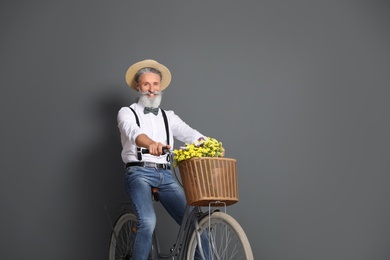 Photo of Portrait of handsome mature man with bicycle on color background