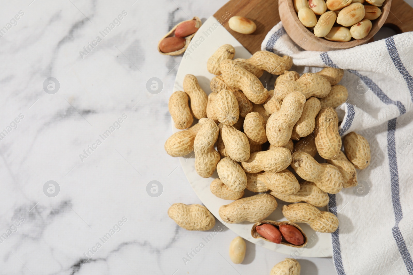 Photo of Fresh peanuts on white marble table, flat lay. Space for text