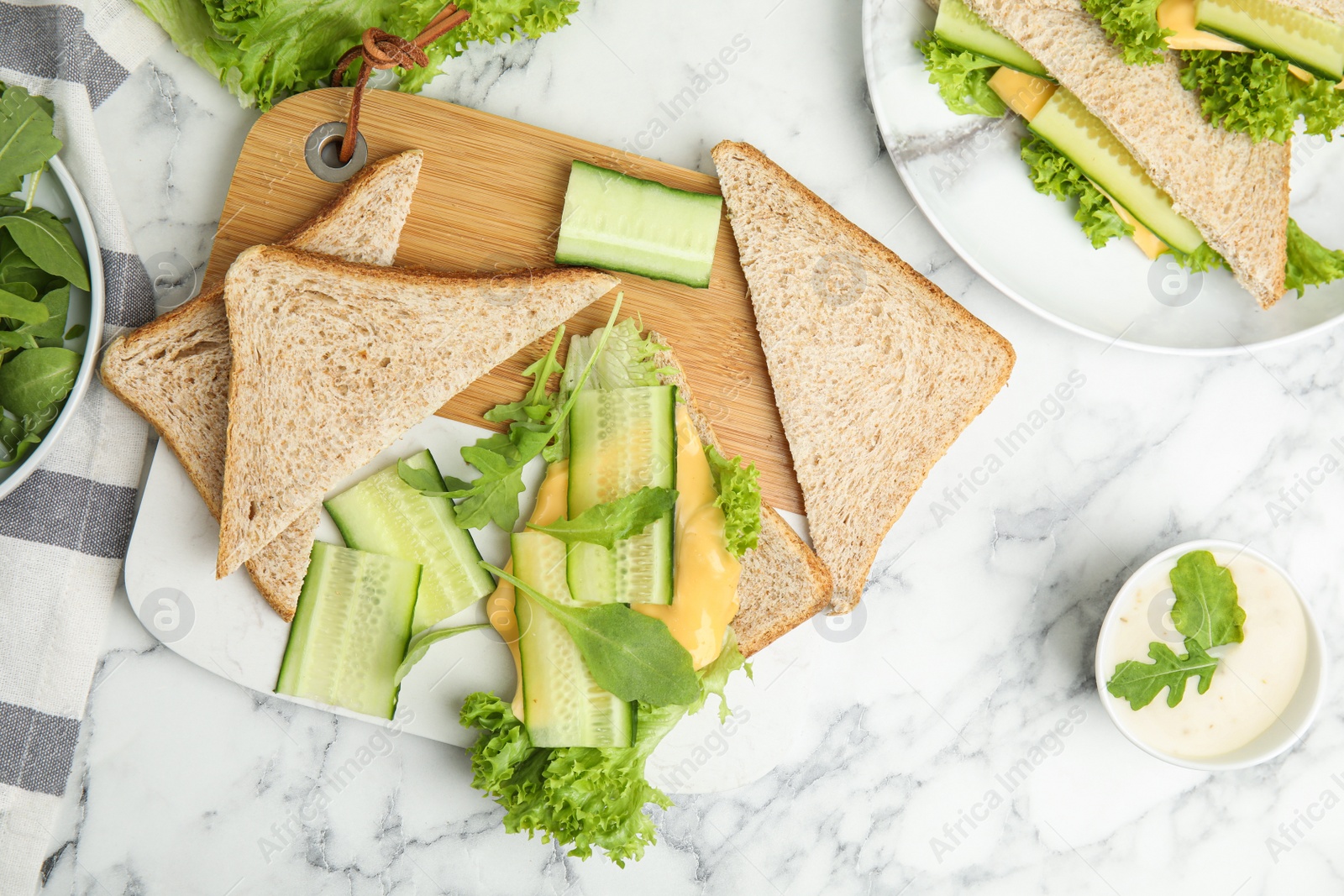 Photo of Flat lay composition with tasty sandwich and ingredients on white marble table