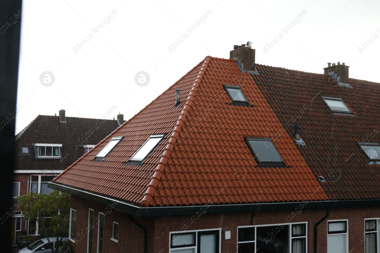 Photo of Beautiful buildings with tiled roofs and chimneys in city under sky