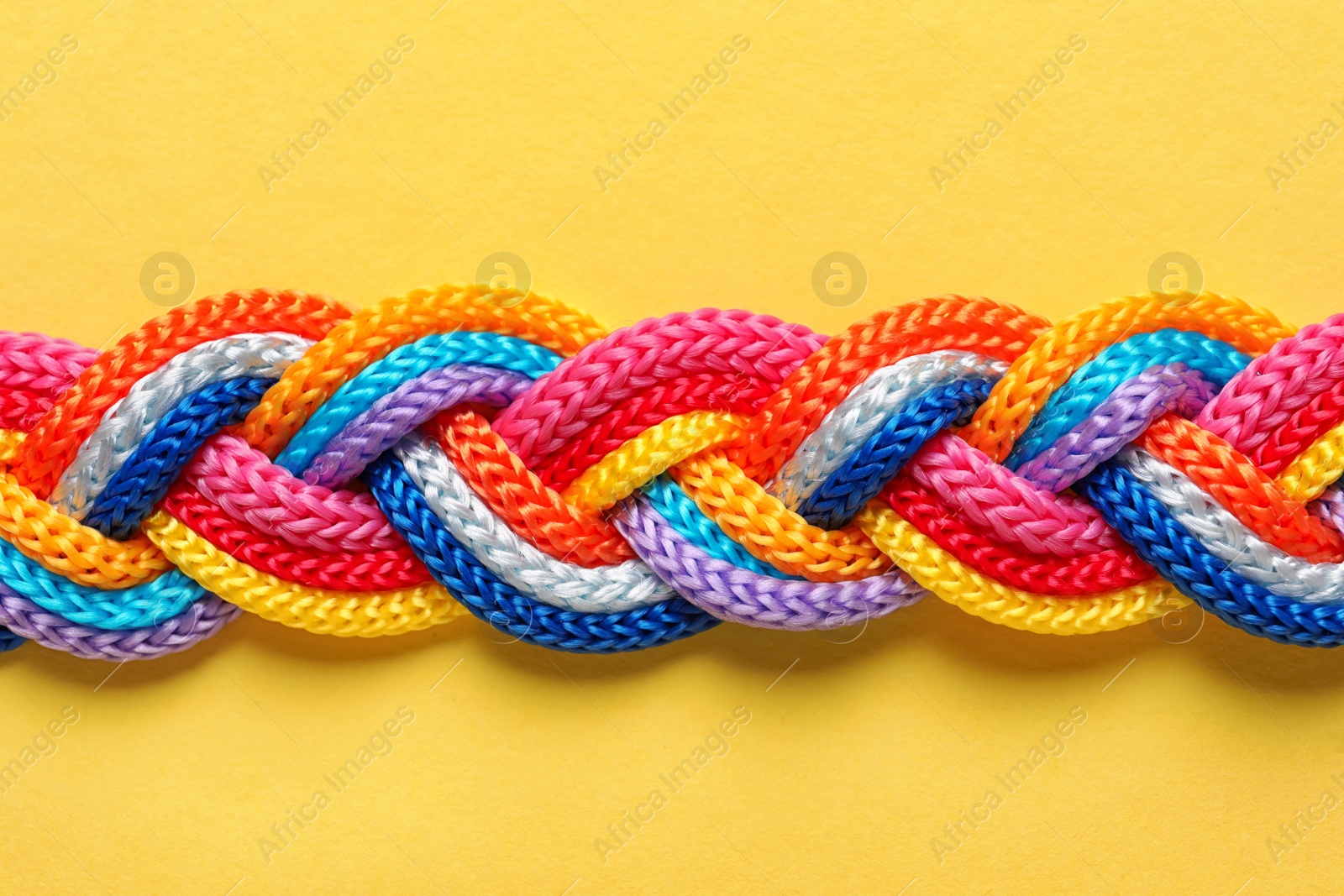 Photo of Braided ropes on color background, top view. Unity concept