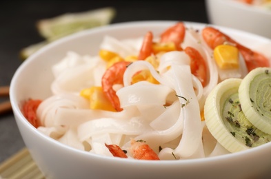 Photo of Bowl with rice noodles, shrimps and vegetables, closeup