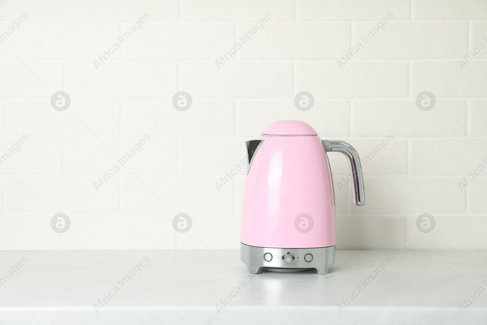 Photo of Modern electric kettle on counter in kitchen. Space for text