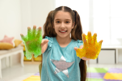 Photo of Preteen girl with slime in playroom, focus on hands