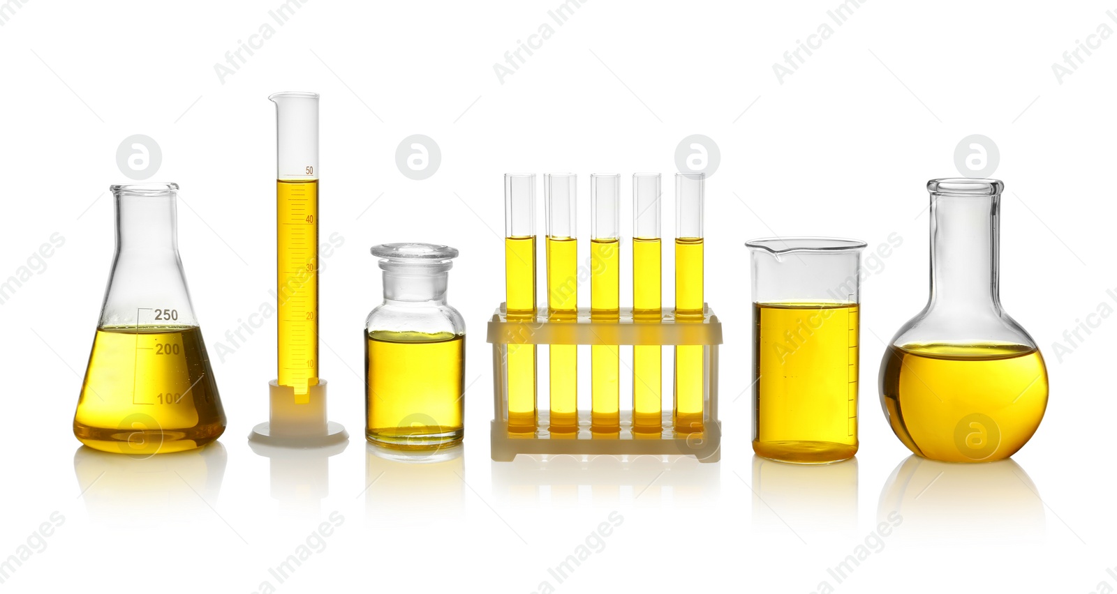 Photo of Laboratory glassware with yellow liquid on white background